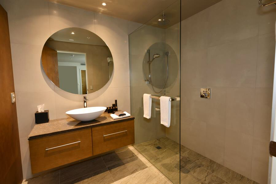 White marble ensuite with black fittings and pendant lights