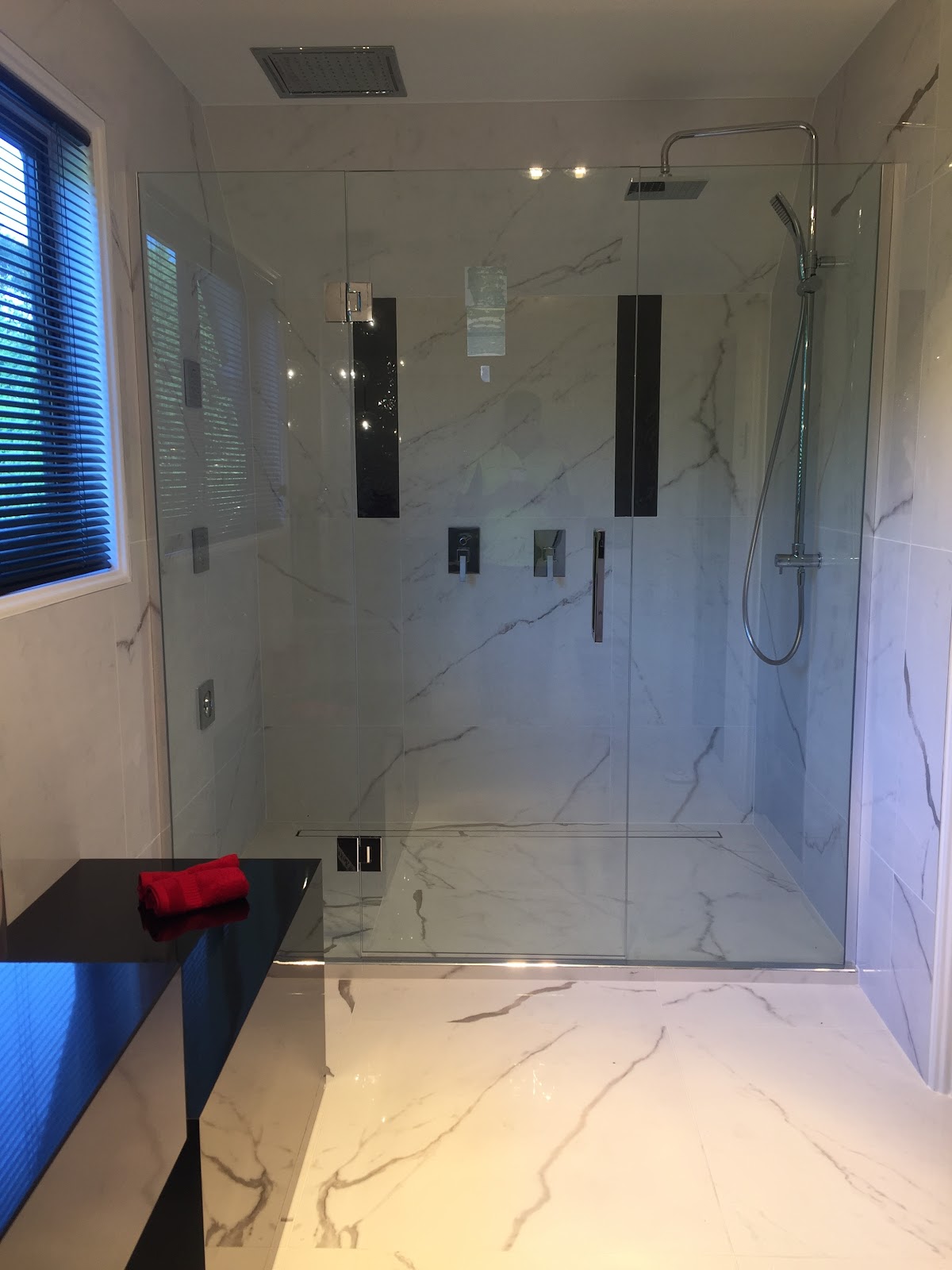 Bathroom with round mirror, timber vanity and tiled walk-in shower